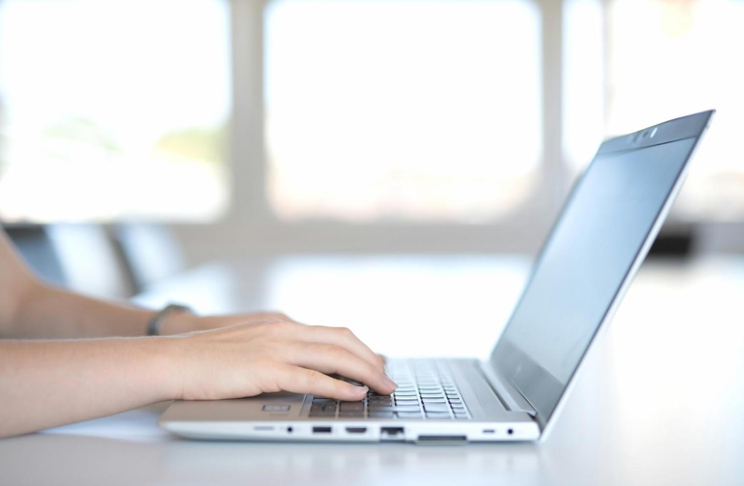 Person reviewing investment portfolio on laptop with financial charts